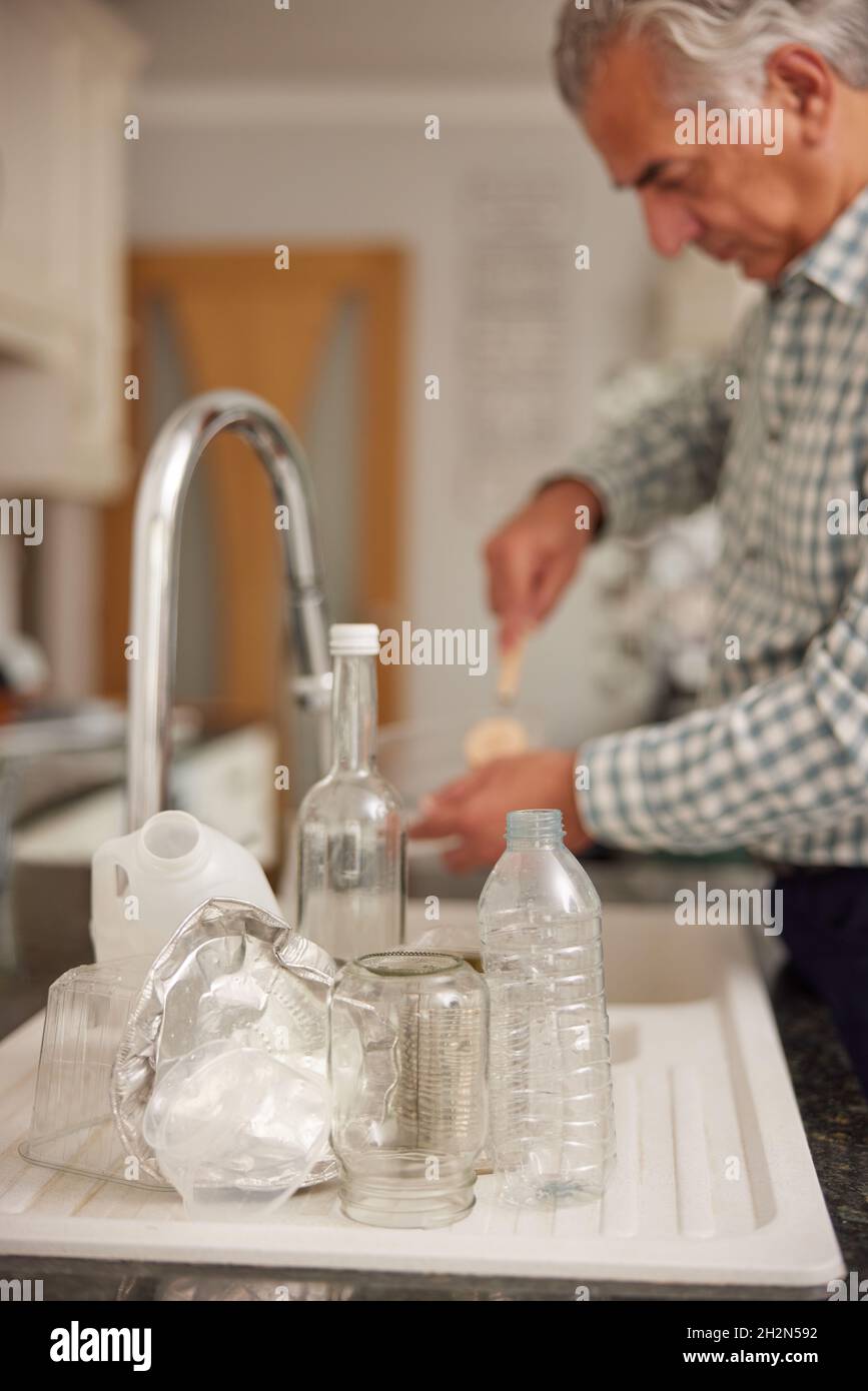 Reifer Mann Zu Hause In Der Küche Waschen Gebrauchte Verpackung Vor Dem Recycling Stockfoto