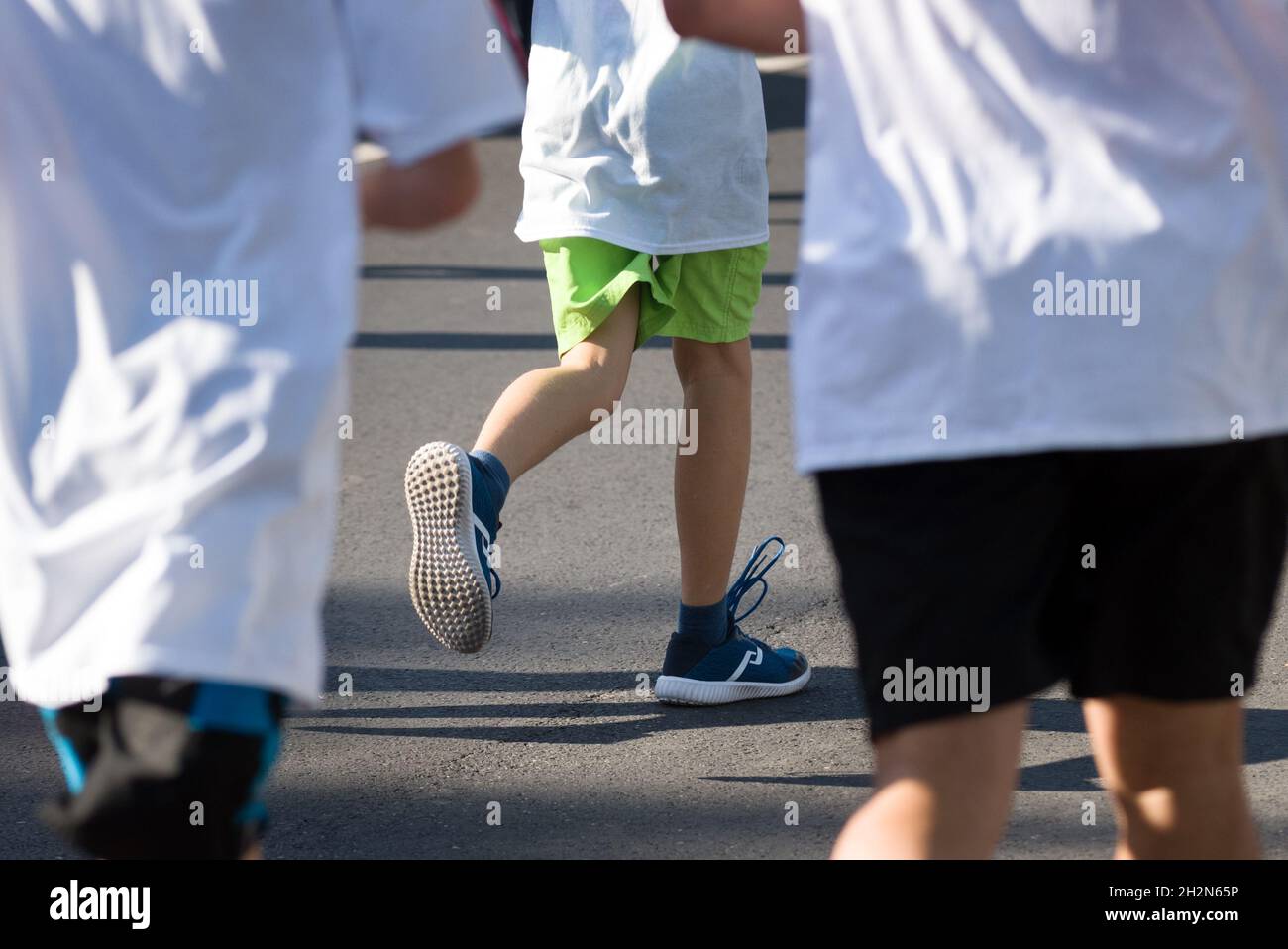 Füße eines Kindes, das in einem Team läuft Stockfoto