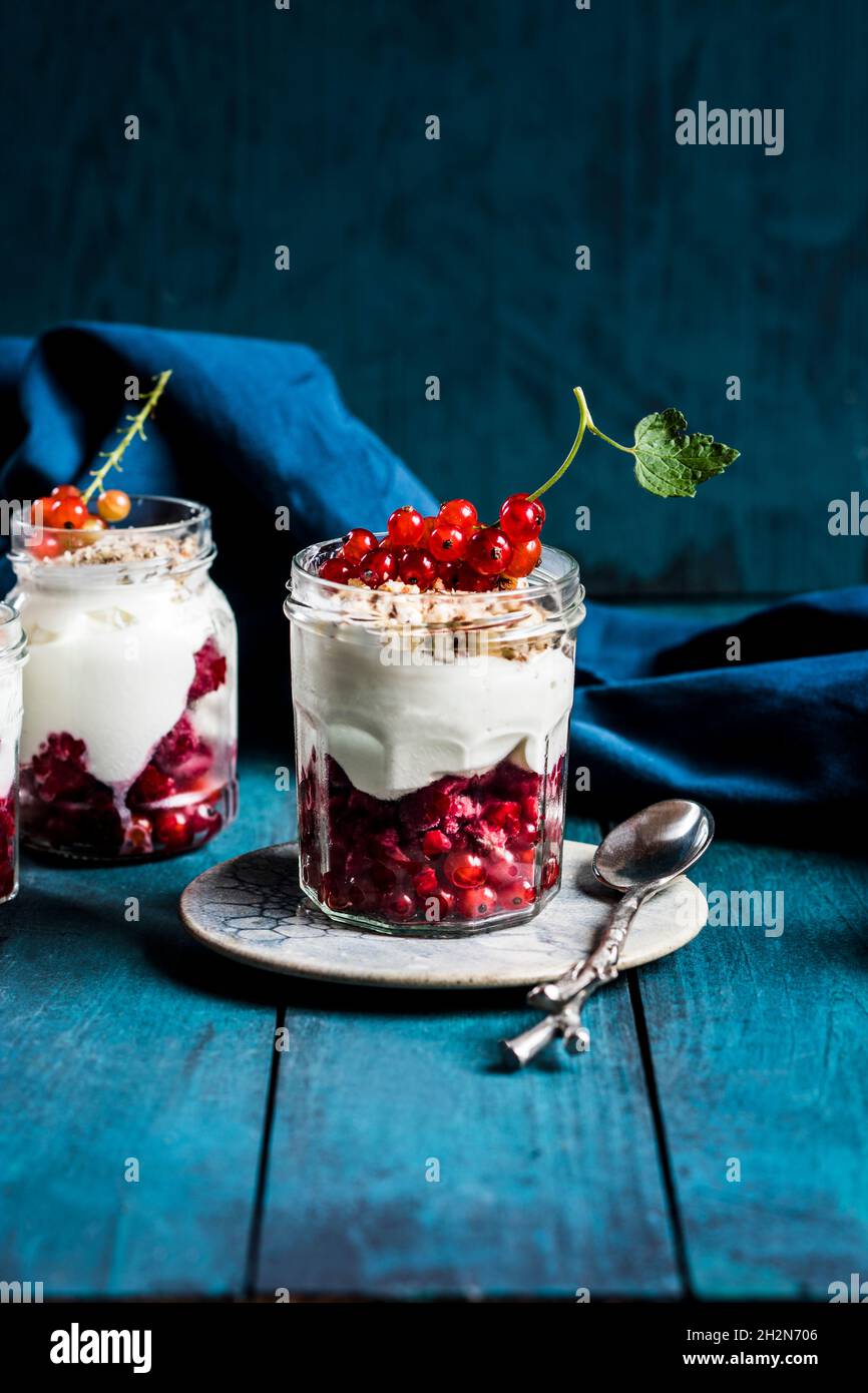 Joghurt-Parfait mit roten Johannisbeeren und Nüssen Stockfoto