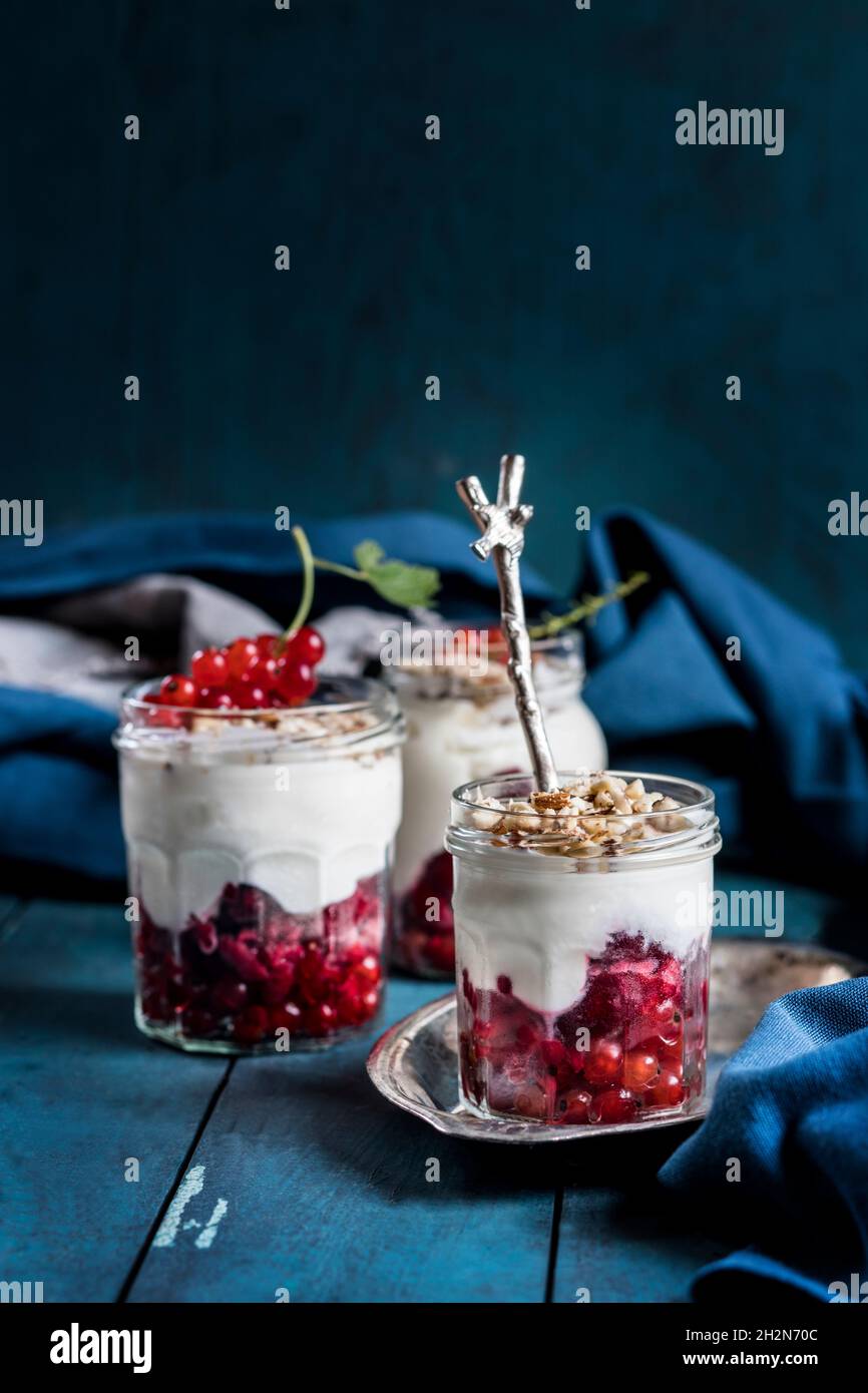 Joghurt-Parfait mit roten Johannisbeeren und Nüssen Stockfoto