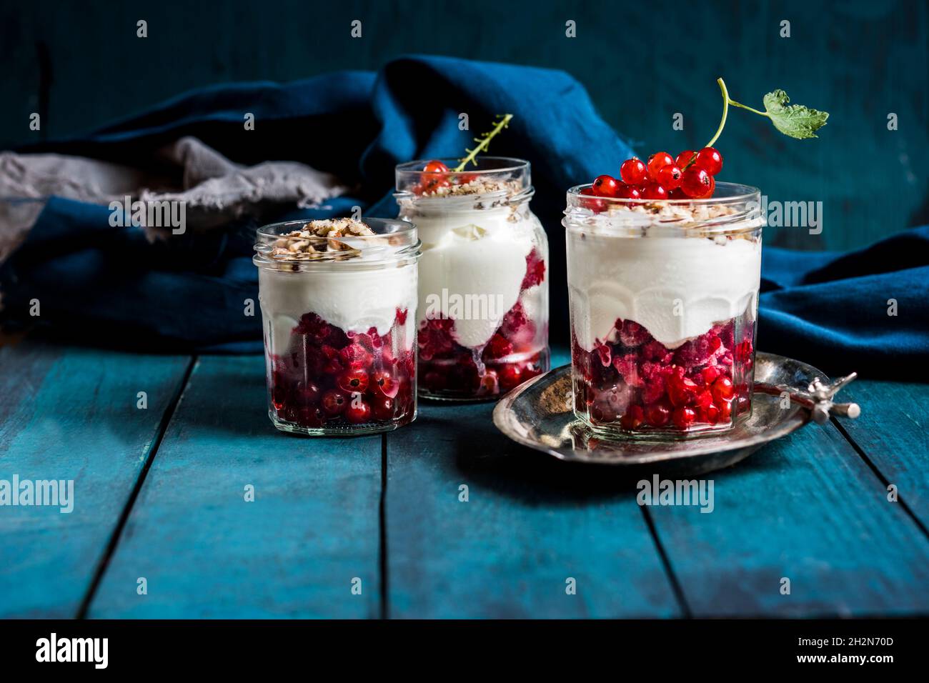 Joghurt-Parfait mit roten Johannisbeeren und Nüssen Stockfoto