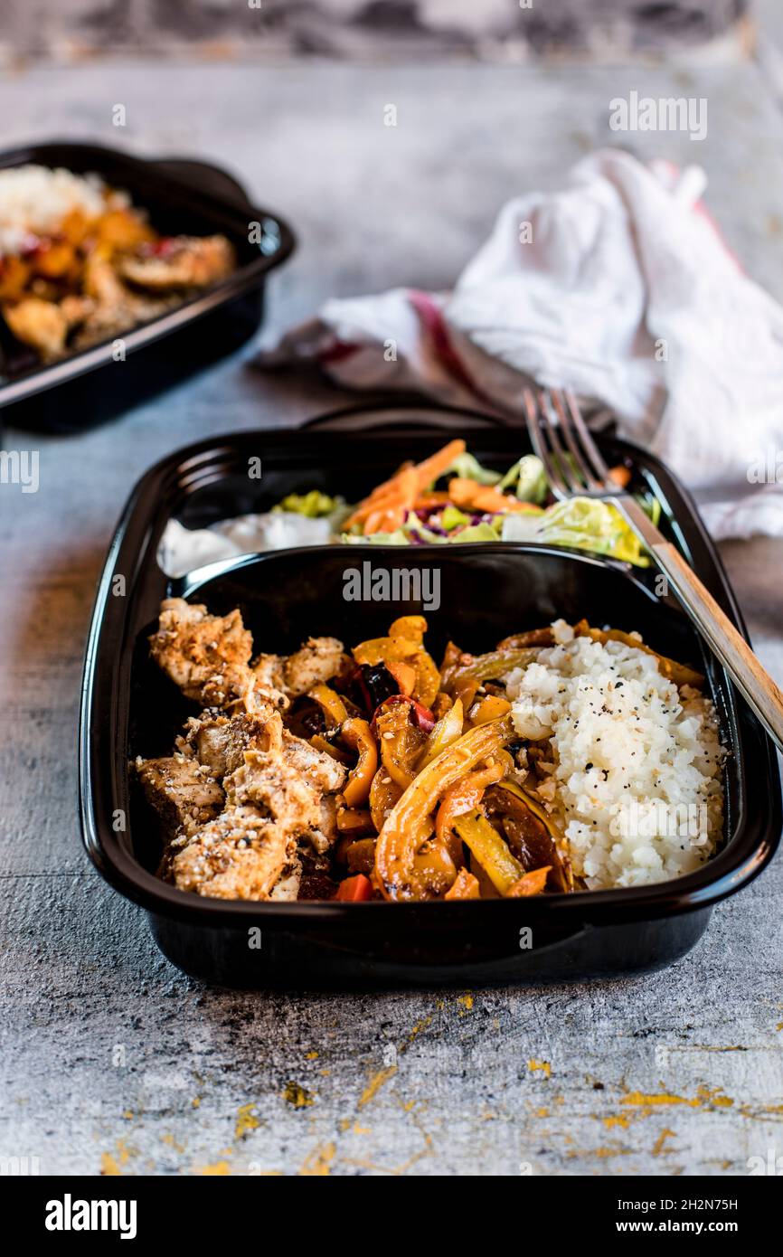 Verzehrfertige Fajita-Schüssel mit Huhn, Salat, gebratener Paprika und Blumenkohlereis Stockfoto