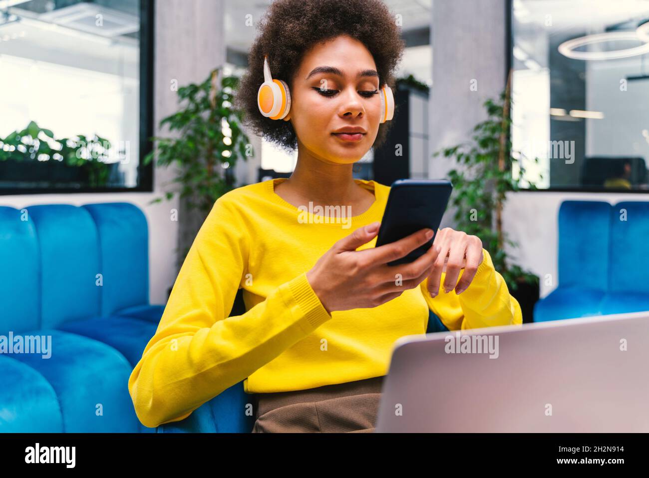 Geschäftsfrau, die drahtlose Technologien in der Bürolobby verwendet Stockfoto