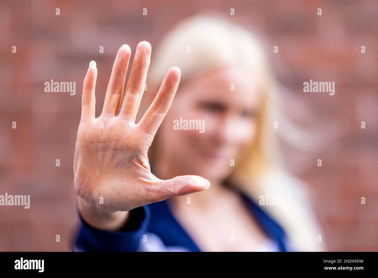 Frau zeigt Stoppschild mit Handfläche Stockfoto