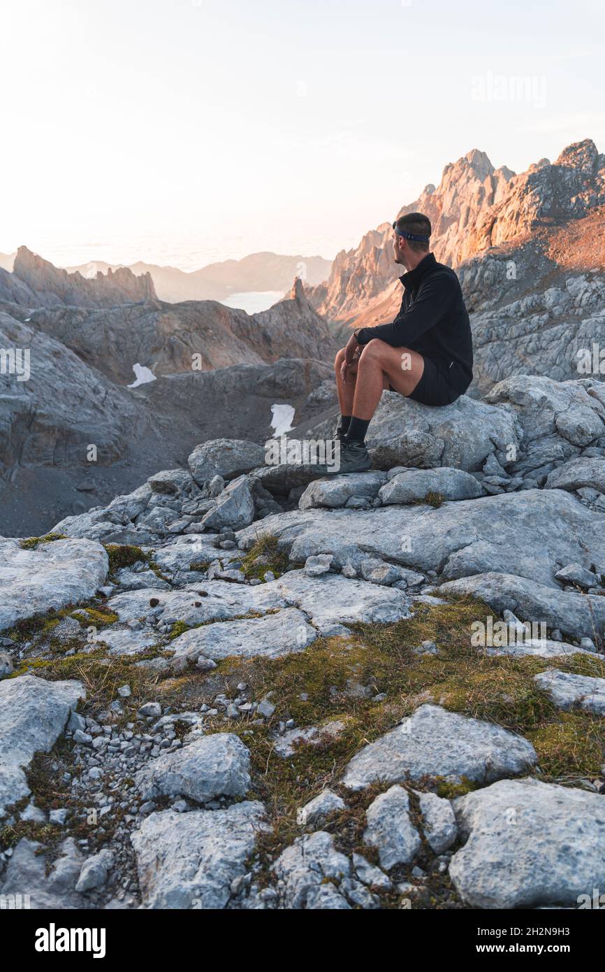 Männlicher Tourist mit Blick auf die Picos de Europe Bergketten bei Sonnenaufgang, Kantabrien, Spanien Stockfoto