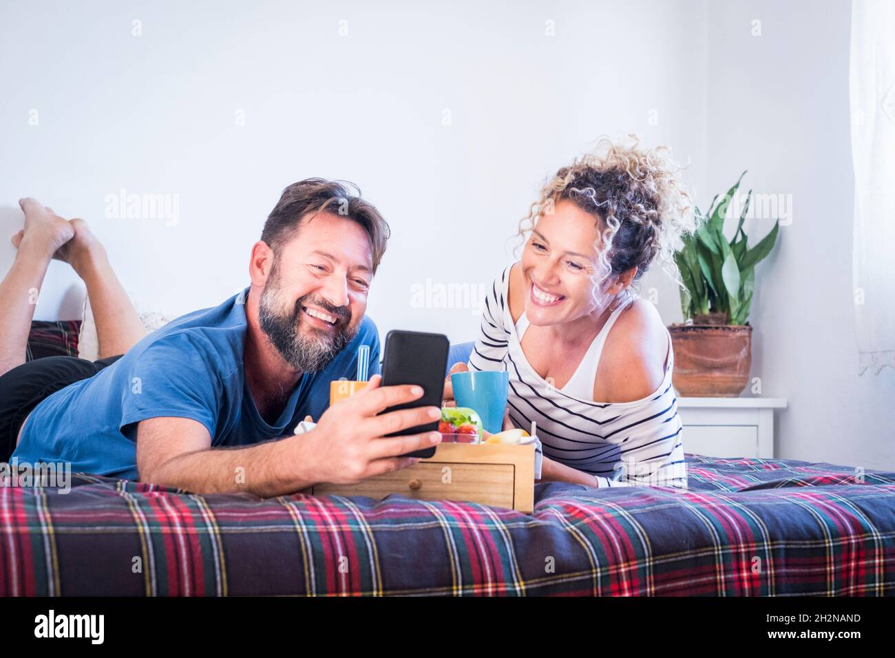 Das Paar frühstückte während eines Videoanrufs über das Smartphone zu Hause Stockfoto