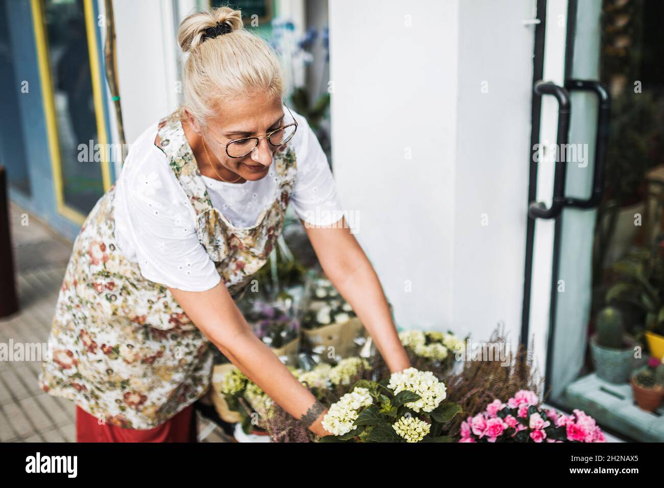 Glücklich reifen weiblichen Floristen mit digitalen Tablet im Blumenladen Stockfoto