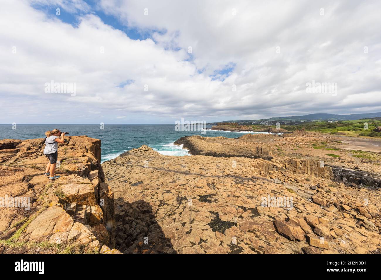 Männlicher Tourist, der Cathedral Rocks am Jones Beach, Australien, fotografiert Stockfoto