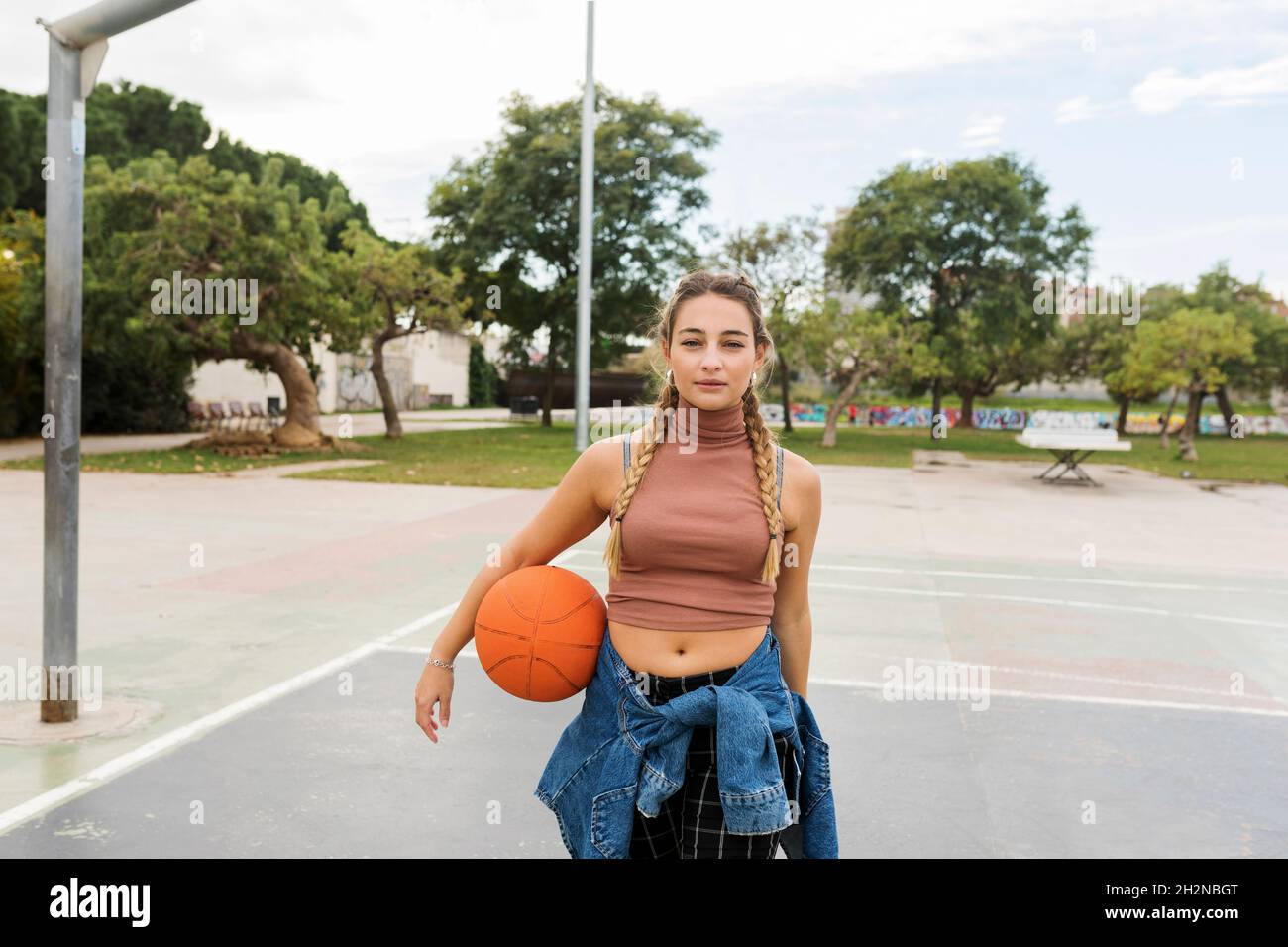 Junge Frau mit Basketball auf dem Sportplatz Stockfoto