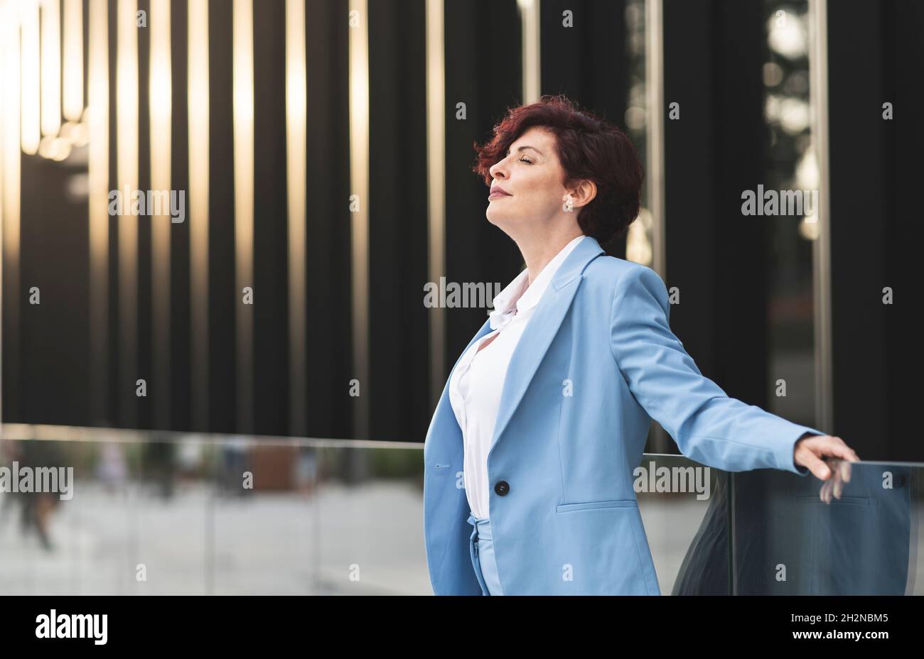 Geschäftsfrau mit kurzen Haaren vor dem Bürogebäude Stockfoto