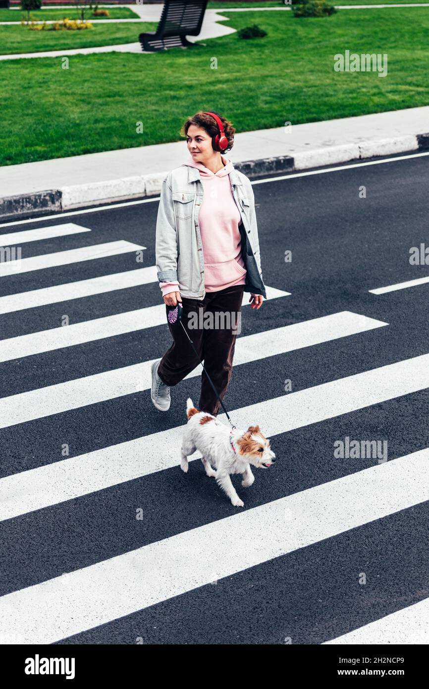 Lächelnde Frau mit Jack Russell Terrier über die Straße Stockfoto