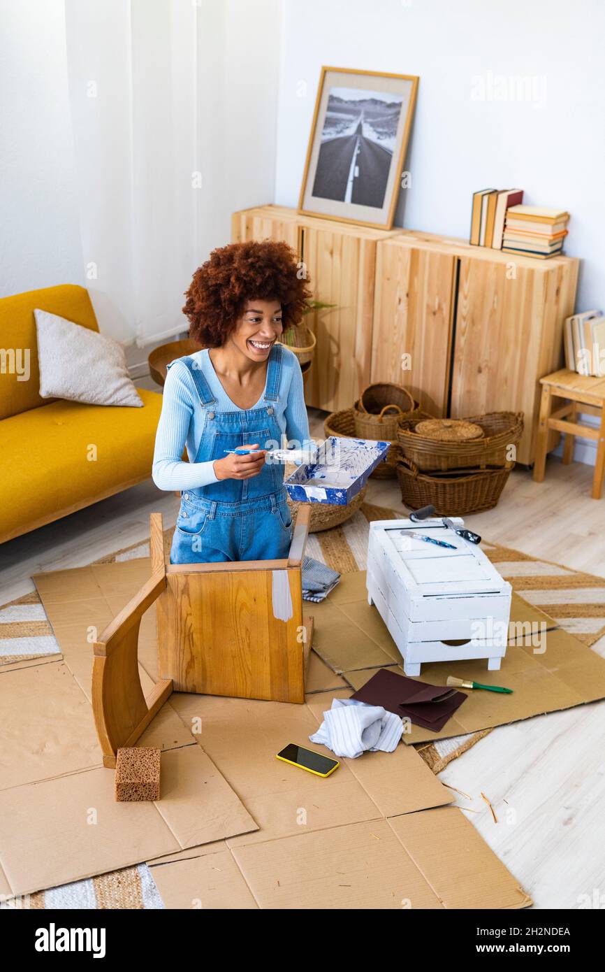 Junge Frau malt zu Hause einen alten Stuhl Stockfoto Junge Frau malt zu Hause einen alten Stuhl Stockfoto