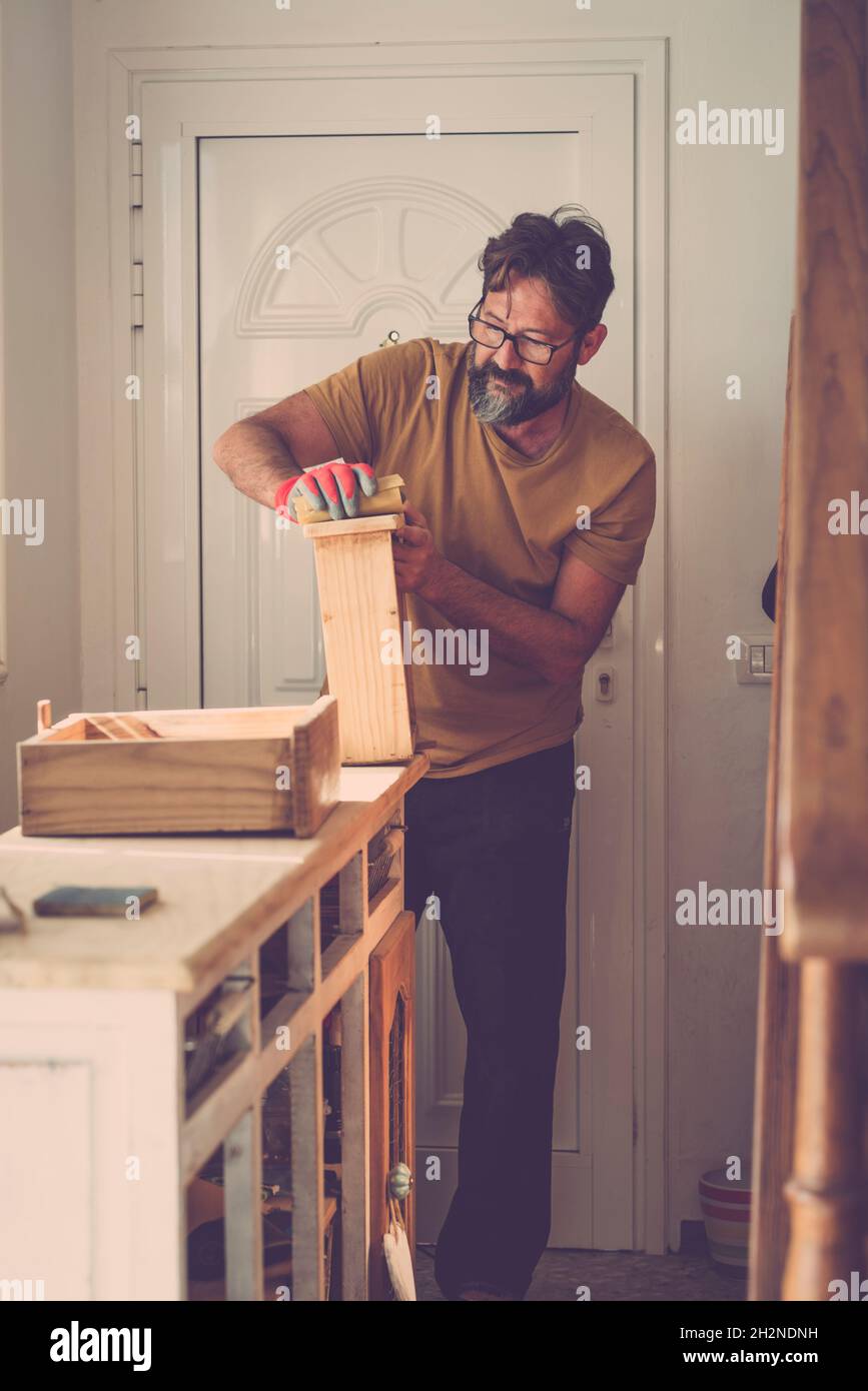 Handwerker, der zu Hause Holz schleift Stockfoto