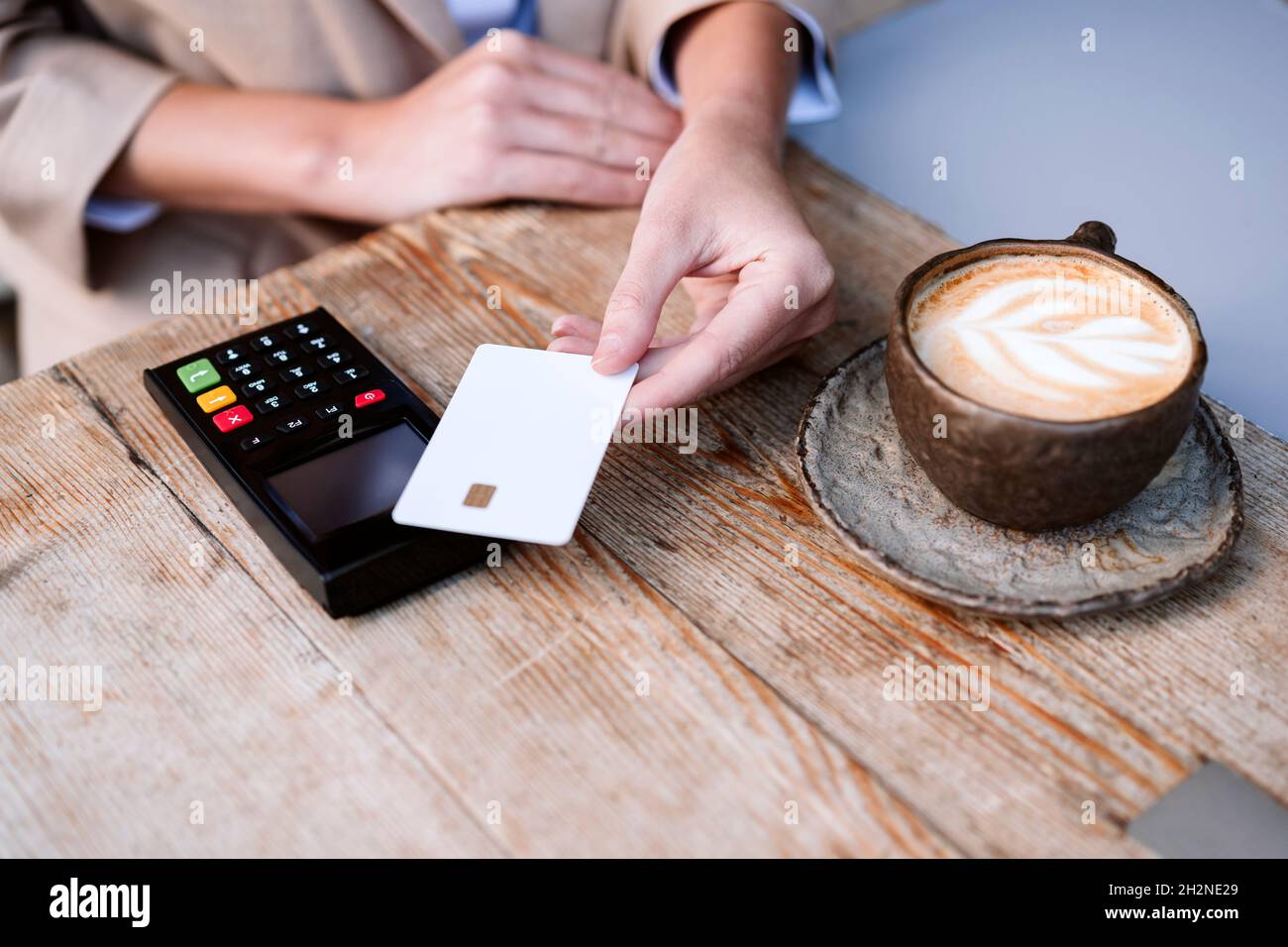 Geschäftsfrau, die auf der Terrasse des Cafés mit Kreditkarte bezahlt Stockfoto