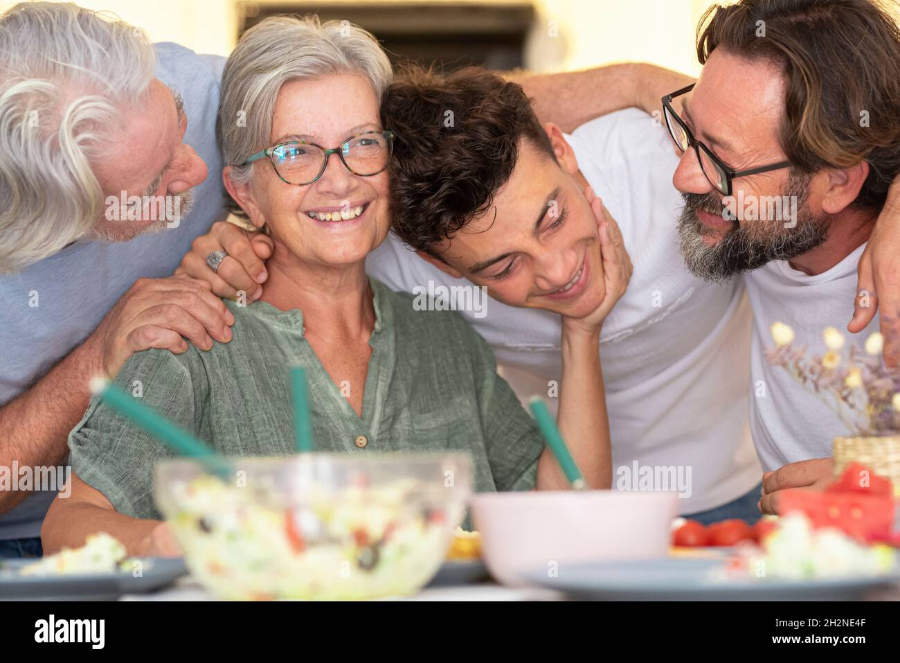 Glückliche Familie mit Arm um einander am Esstisch Stockfoto