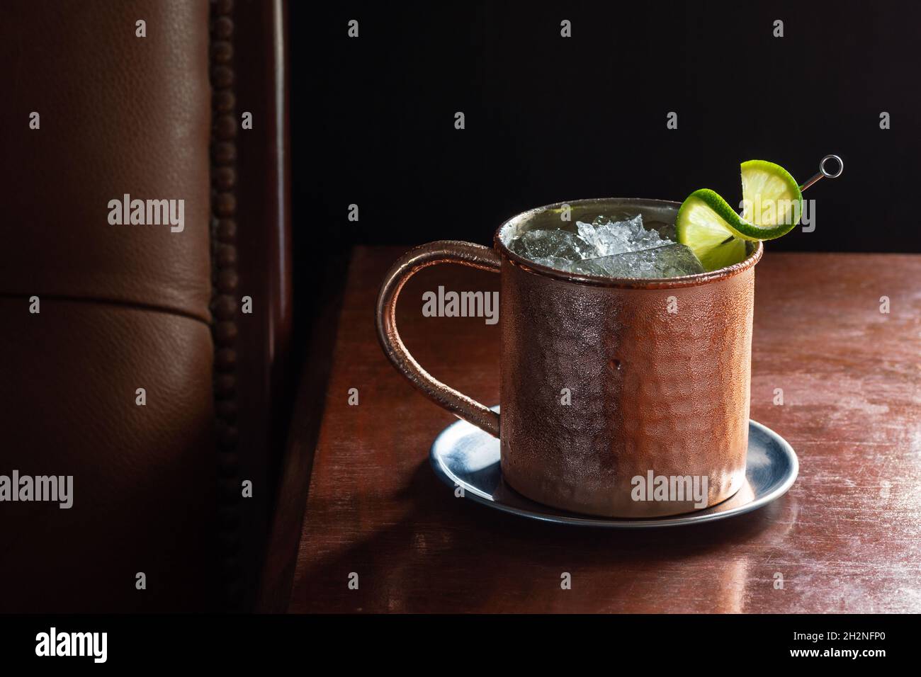 Moscow Mule Cocktail Drink mit Crushed Ice und Lime im Kupferbecher in der dunklen luxuriösen Bar Stockfoto
