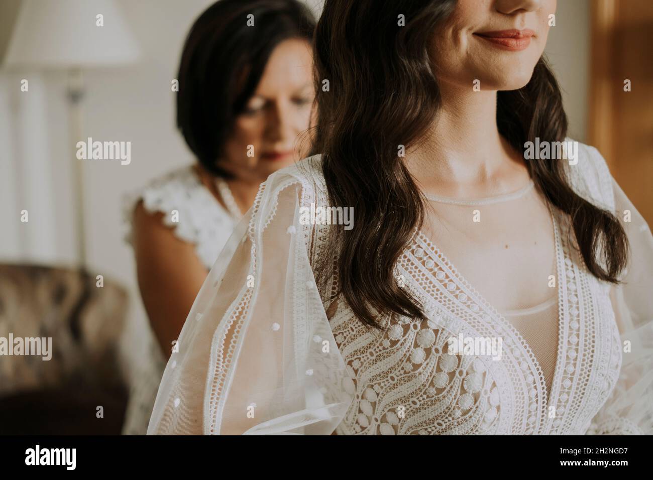 Lächelnde Frau, die sich zu Hause auf die Hochzeit vorbereitet Stockfoto