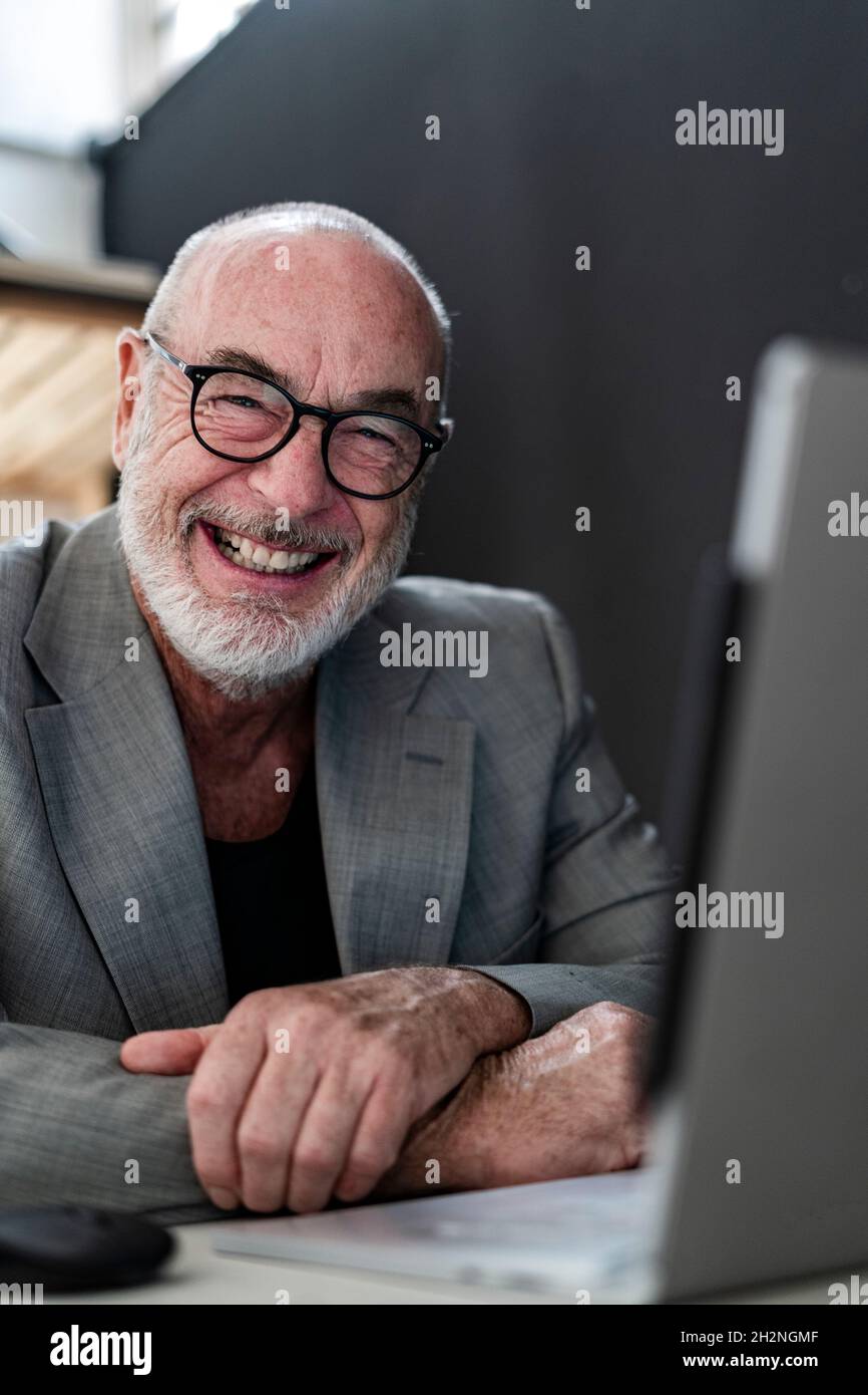Glücklicher männlicher Profi mit Laptop im Studio Stockfoto Glücklicher männlicher Profi mit Laptop im Studio Stockfoto