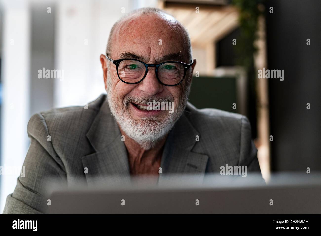 Fröhlicher Geschäftsmann mit Laptop im Studio Stockfoto