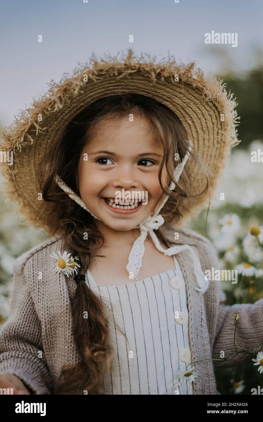 Lächelndes Mädchen trägt Blume im Haar Stockfoto