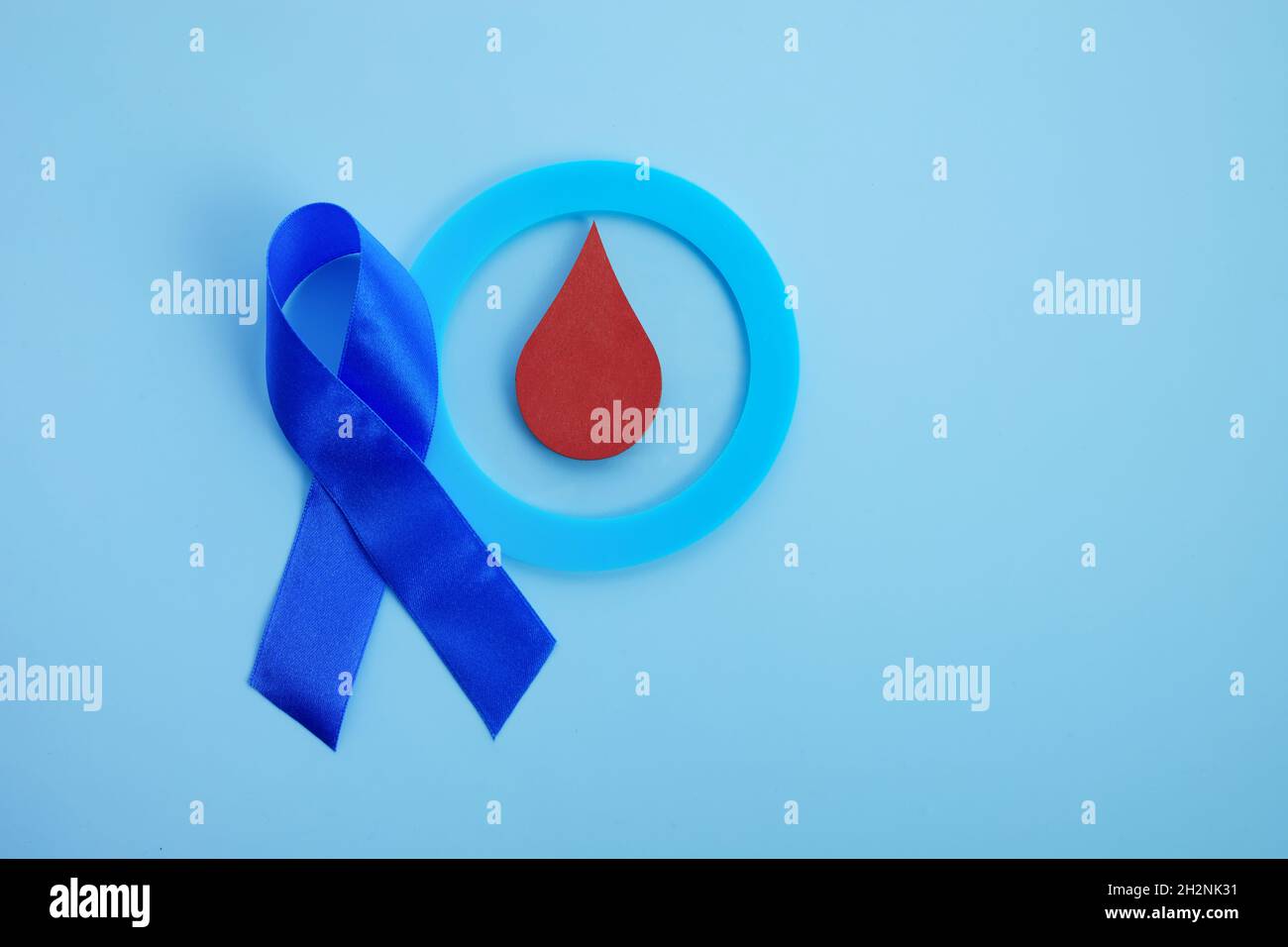 Bewusstsein für den Weltdiabetestag. Blaues Band und Kreis mit Blutstropfen. Stockfoto