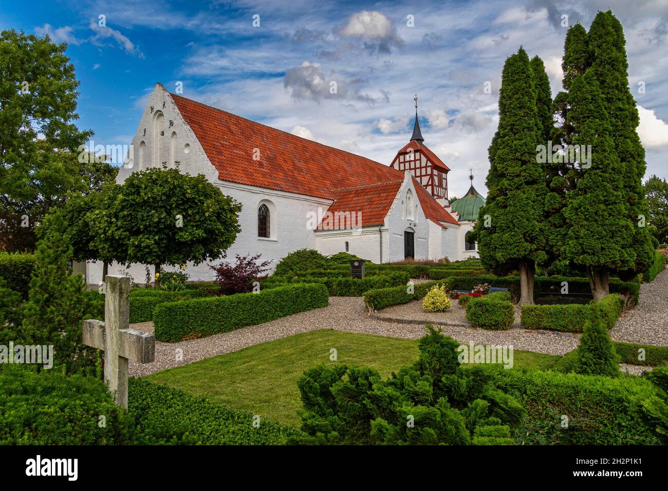 Die Kirche von Jelling steht auf dem Grab des ersten Wikingers, der das Christentum in Dänemark angenommen hat.an seiner Seite erzählen die Runensteine die Geschichte.Welterbe Stockfoto