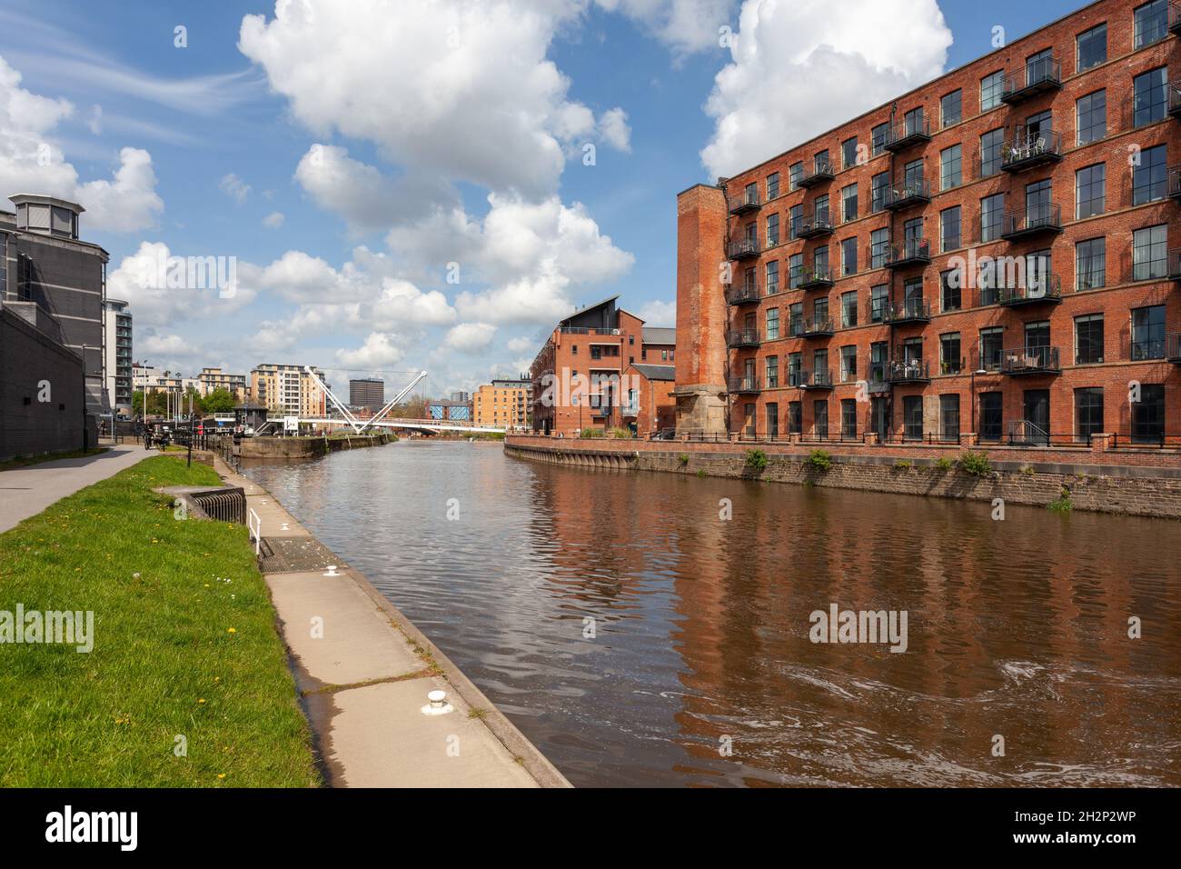 Lagerhäuser, die in Apartments am Wasser neben dem Fluss Aire in Leeds umgewandelt wurden Stockfoto