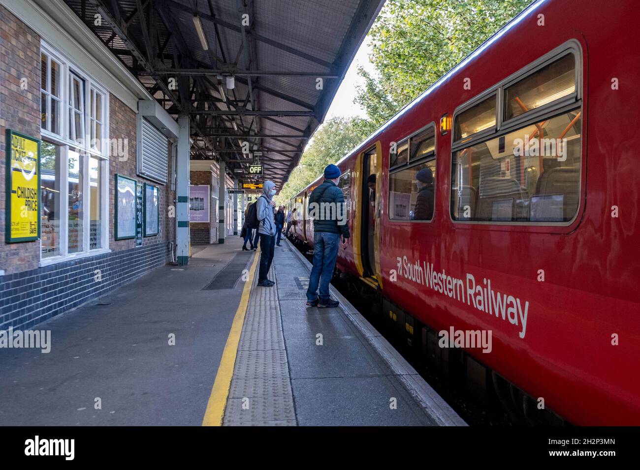 South Western Railway Commuter Train wartet auf Passagiere am Epsom Bahnhof Surrey England UK mit Menschen auf der Plattform stehen Stockfoto