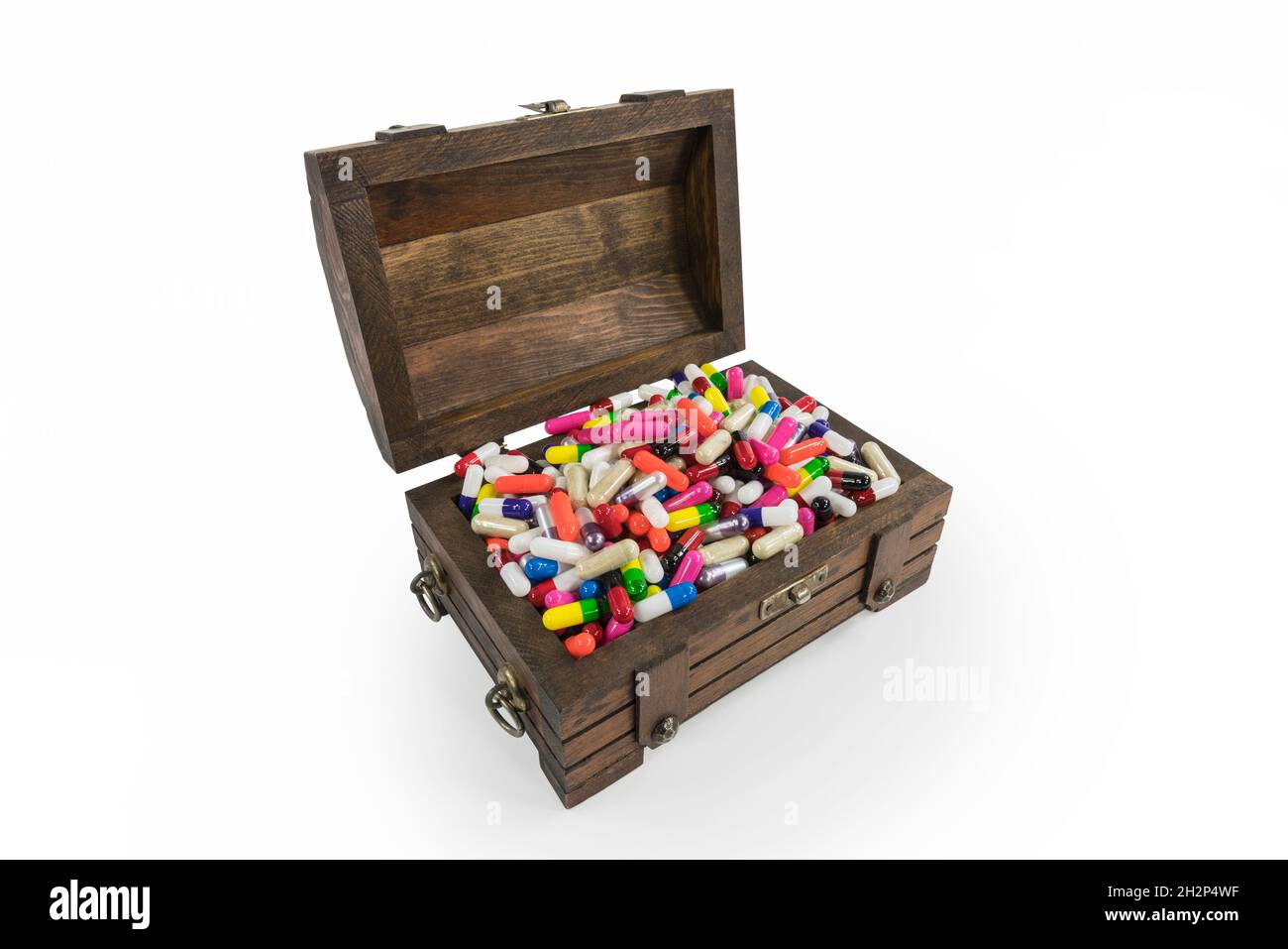 Alte Holzspielzeug Schatzkiste überfüllt mit Pillen und Kapseln. Stockfoto