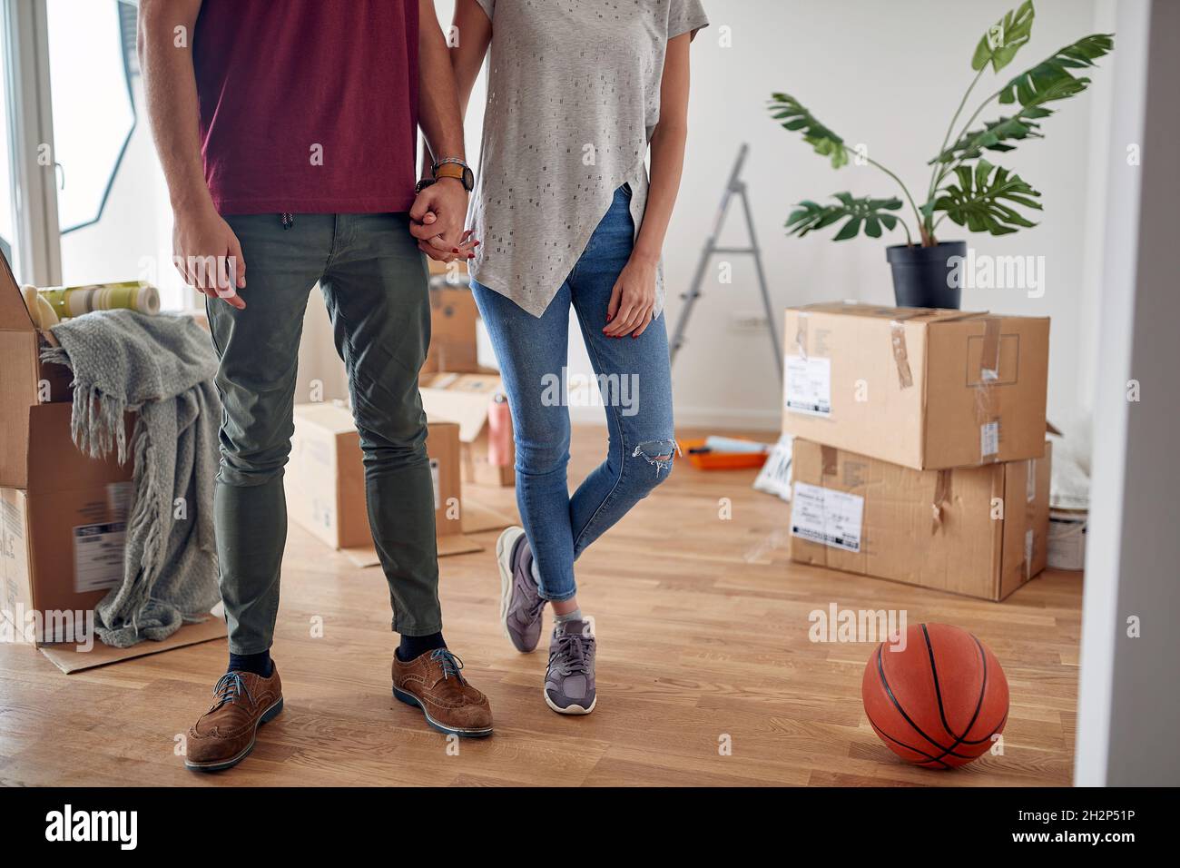 Detail, abgeschnitten Bild von jungen Paar Hände in neue Wohnung mit ausgepackten Boxen um sie halten Stockfoto