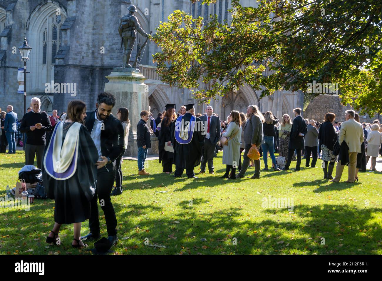 Abschlussfeier. Studenten der University of Winchester treffen sich mit Freunden und Familie bei der Abschlussfeier vor der Winchester Cathedral, Hampshire, Großbritannien Stockfoto