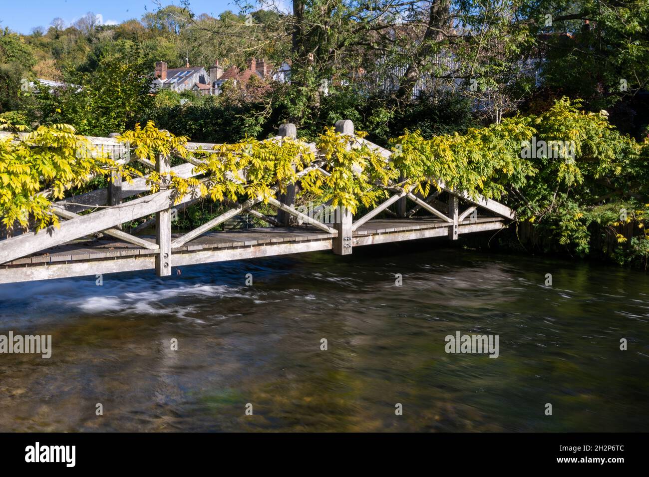 Eine Fußgängerbrücke über den kristallklaren Fluss Itchen in Winchester, Hampshire, Großbritannien Stockfoto