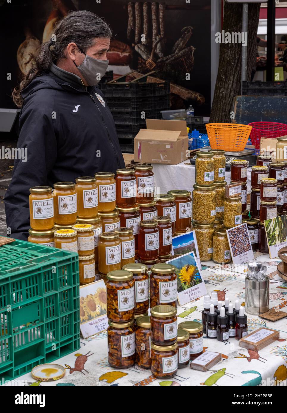 Covid-maskierter Händler und Honig auf dem Samstagsmarkt, Place Jean Jacques Chapou, Cahors, Frankreich Stockfoto