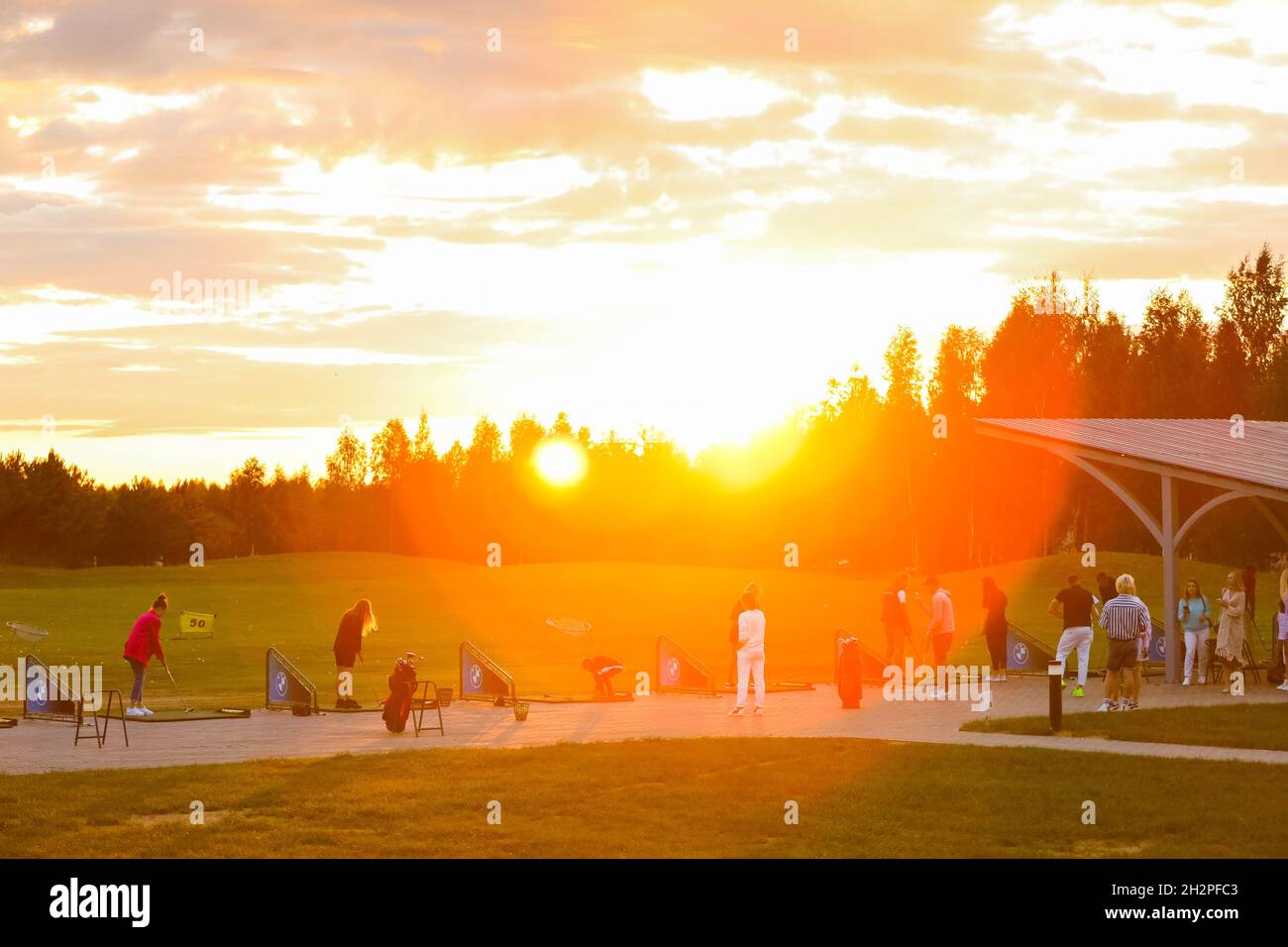 Golfplatz bei Sonnenuntergang, Sonnenstrahlen, Golfer am Abend in Sonnenstrahlen. Hochwertige Fotos Stockfoto