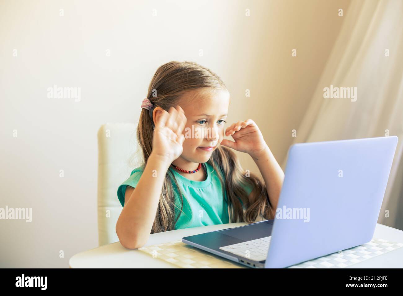 Kleines nettes Mädchen verwendet Laptop, um Videoanruf zu haben Stockfoto