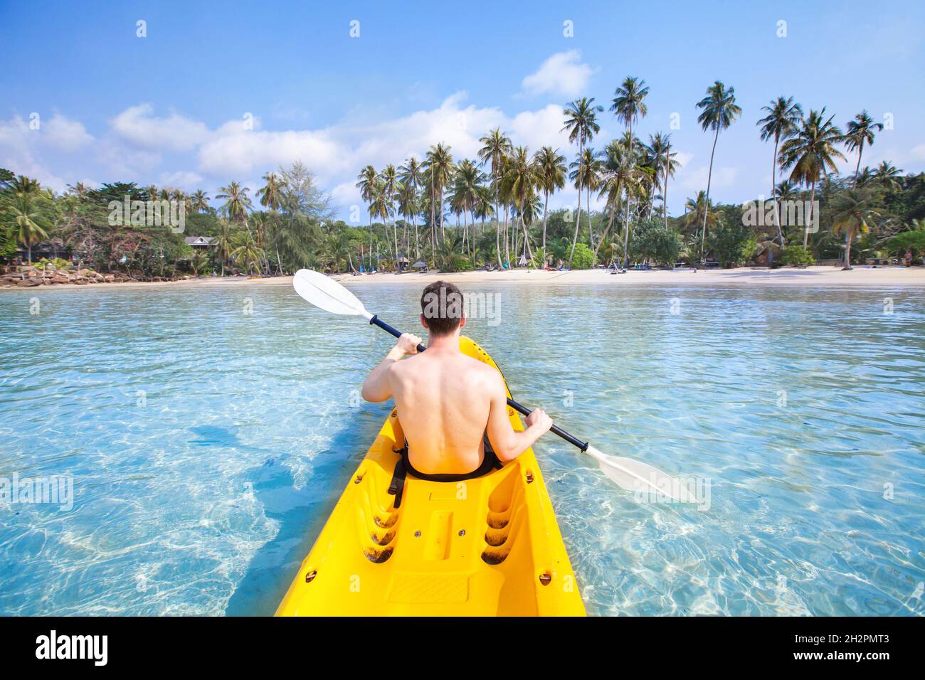 Kajakfahren am tropischen Strand, Reisen nach Asien, Sommerferien, Touristenpaddeln mit dem Kajak im türkisfarbenen Meerwasser Stockfoto Kajakfahren am tropischen Strand, Reisen nach Asien, Sommerferien, Touristenpaddeln mit dem Kajak im türkisfarbenen Meerwasser Stockfoto