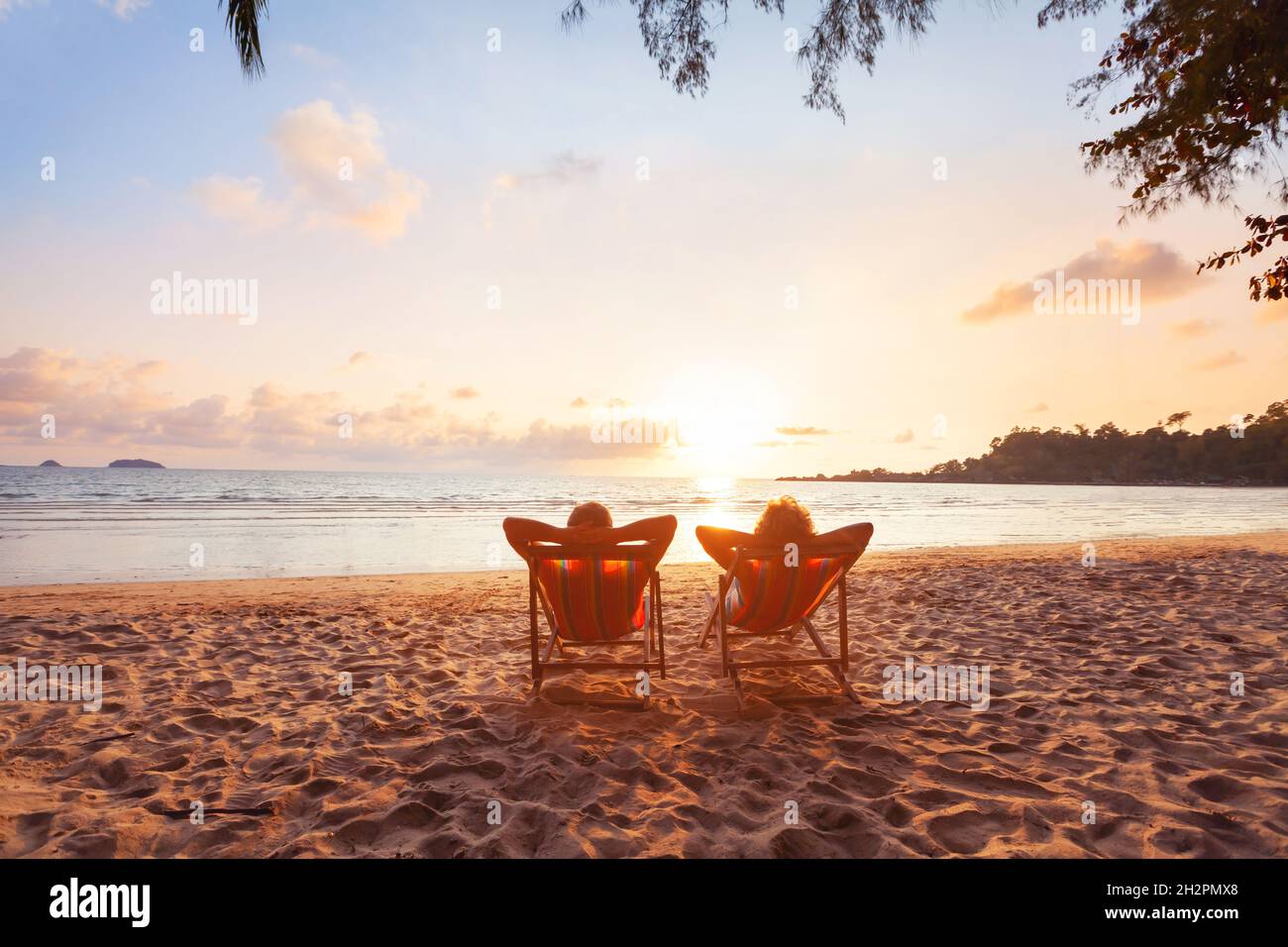 Romantischer Kurzurlaub für Paare, Flitterwochen am Strand, Silhouetten von Männern und Frauen, die sich im Hotel entspannen Stockfoto