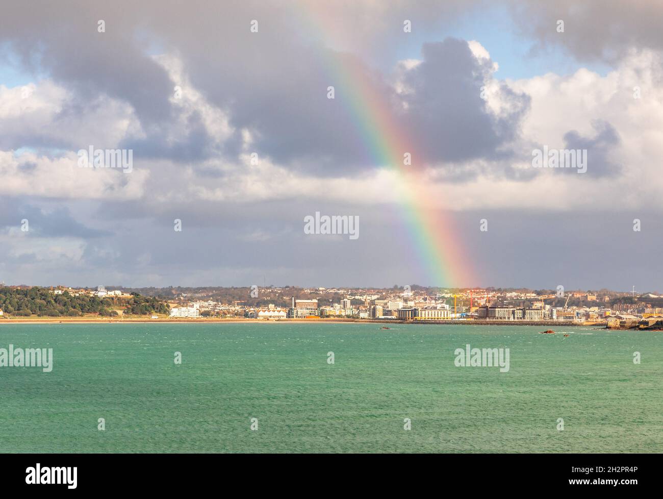 Regenbogen über der Hauptstadt Saint Helier mit Meer im Vordergrund, Vogtei von Jersey, Kanalinseln, Großbritannien Stockfoto