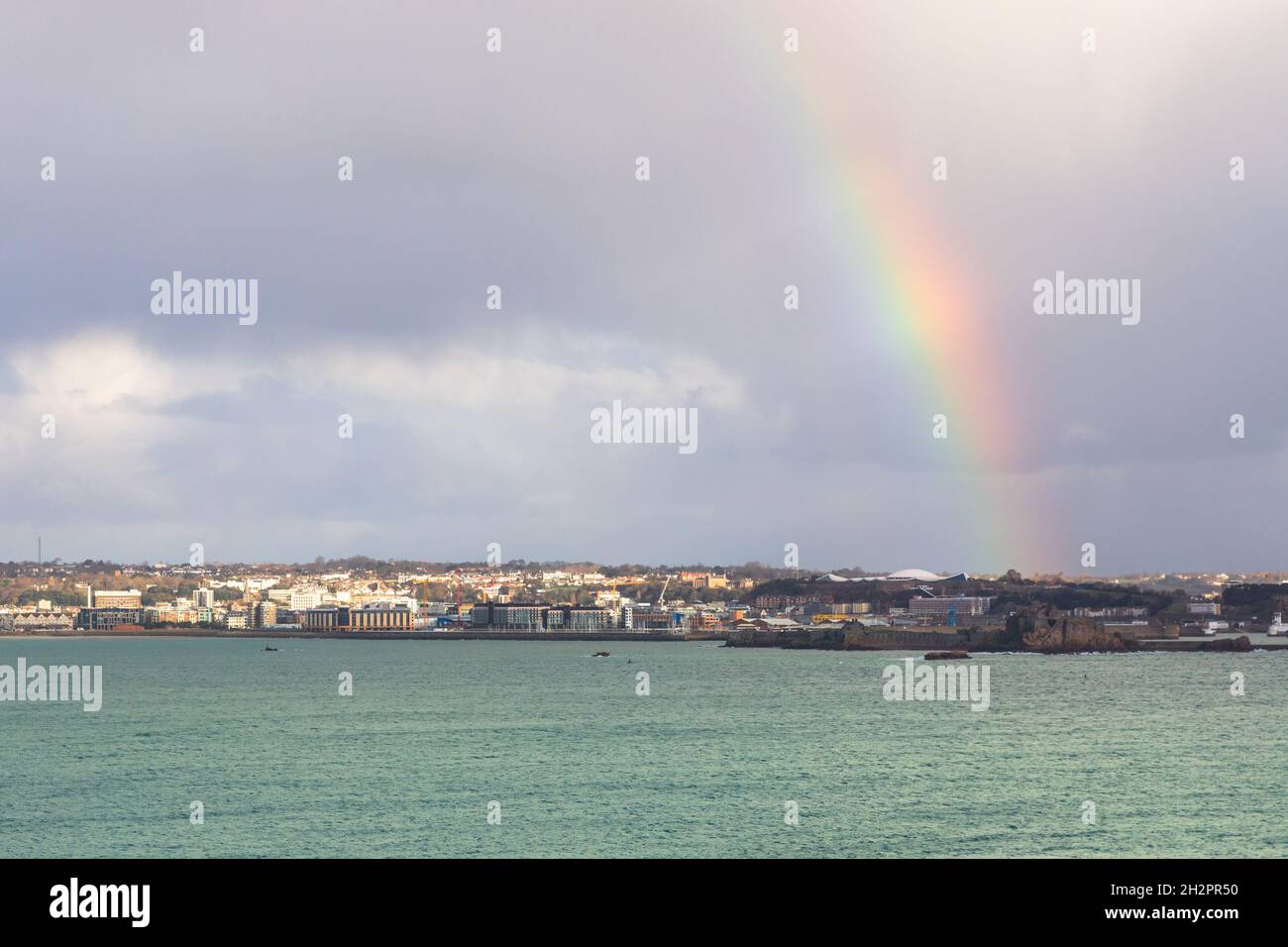 Regenbogen über der Hauptstadt Saint Helier mit Meer im Vordergrund, Vogtei von Jersey, Kanalinseln, Großbritannien Stockfoto