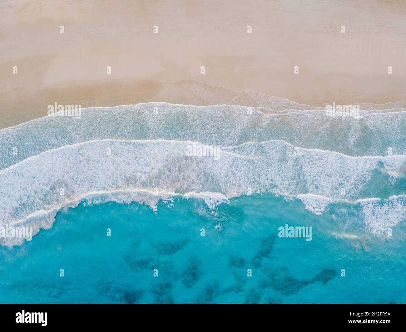 Luftaufnahme des Sandstrandes, Ozeanstruktur im Hintergrund, Draufsicht auf Meereswellen per Drohne. Stockfoto Luftaufnahme des Sandstrandes, Ozeanstruktur im Hintergrund, Draufsicht auf Meereswellen per Drohne. Stockfoto