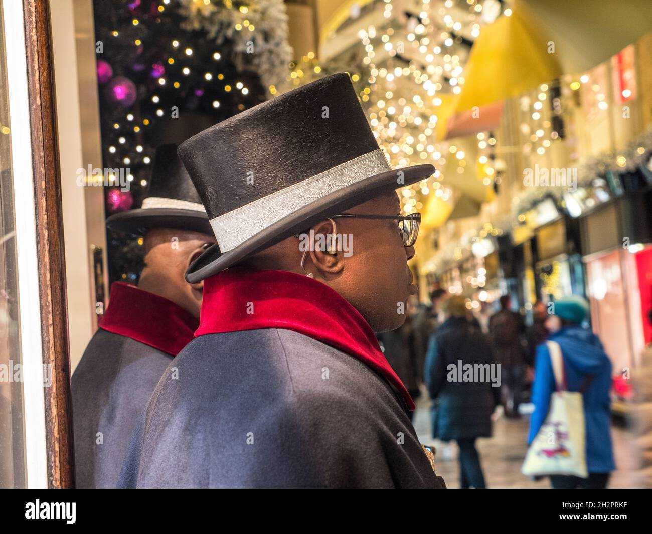 BURLINGTON ARCADE BEADLES SECURITY CHRISTMAS LONDON BEADLES UNIFORM CLOSE-UP PRIVATE TRADITIONELLE SICHERHEITSPOLIZEI UND FESTLICHE SCHAUFENSTER WEIHNACHTSEINKÄUFE SHOPPER INNEN charmante Olde worlde Burlington Arcade in seinem 200. Jahr in Piccadilly mit traditionellen Weihnachtsdekorationen funkelnde Lichter und Massen von Shopper in einem nobleren Einkaufsumfeld London UK Stockfoto