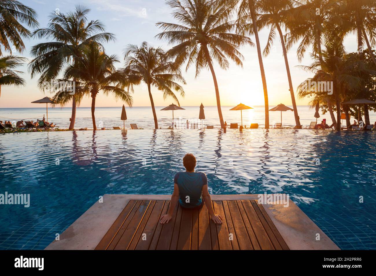 Sommerurlaub im luxuriösen Strandhotel, Erholung für Touristen in der Nähe eines luxuriösen Swimmingpools bei Sonnenuntergang, Urlaub auf einer tropischen Insel Stockfoto Sommerurlaub im luxuriösen Strandhotel, Erholung für Touristen in der Nähe eines luxuriösen Swimmingpools bei Sonnenuntergang, Urlaub auf einer tropischen Insel Stockfoto