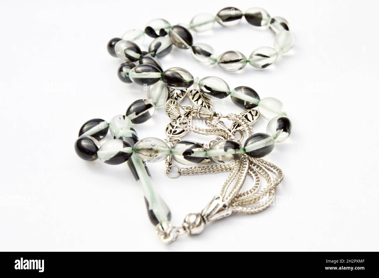 Schwarz-weiße und silberne Perlen sequenziert, kurzer Rosenkranz, Hoden tesbih, ein wichtiges Zubehör für die türkische Kultur, isoliert auf weißem Hintergrund. Stockfoto
