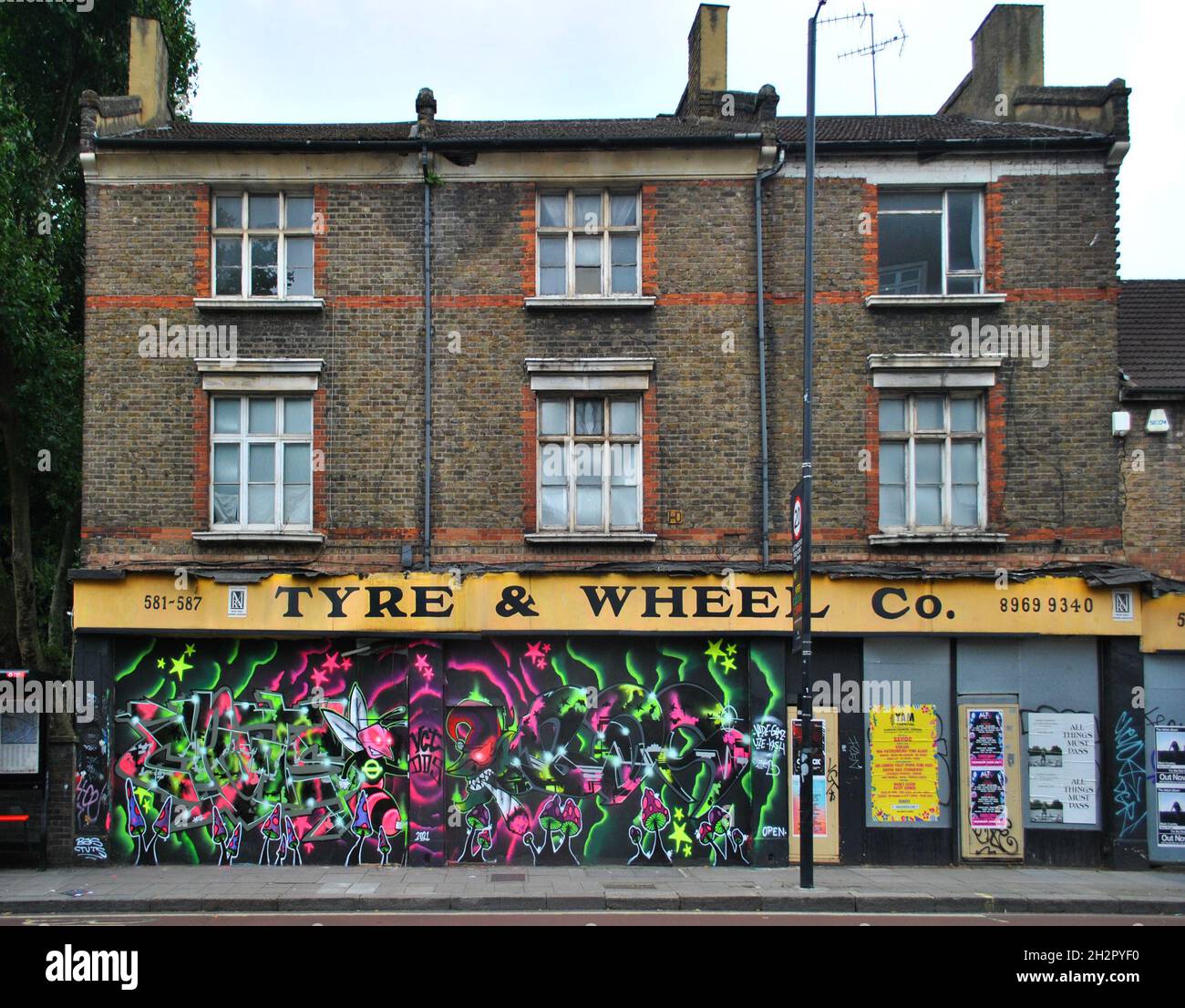 EINE GESCHLOSSENE GARAGE AN DER HARROW ROAD, WEST LONDON, MIT GRAFFITI-KUNSTWERKEN AN DER GESCHLOSSENEN FASSADE. JETZT FÜR 2.5 MILLIONEN ERHÄLTLICH. Stockfoto