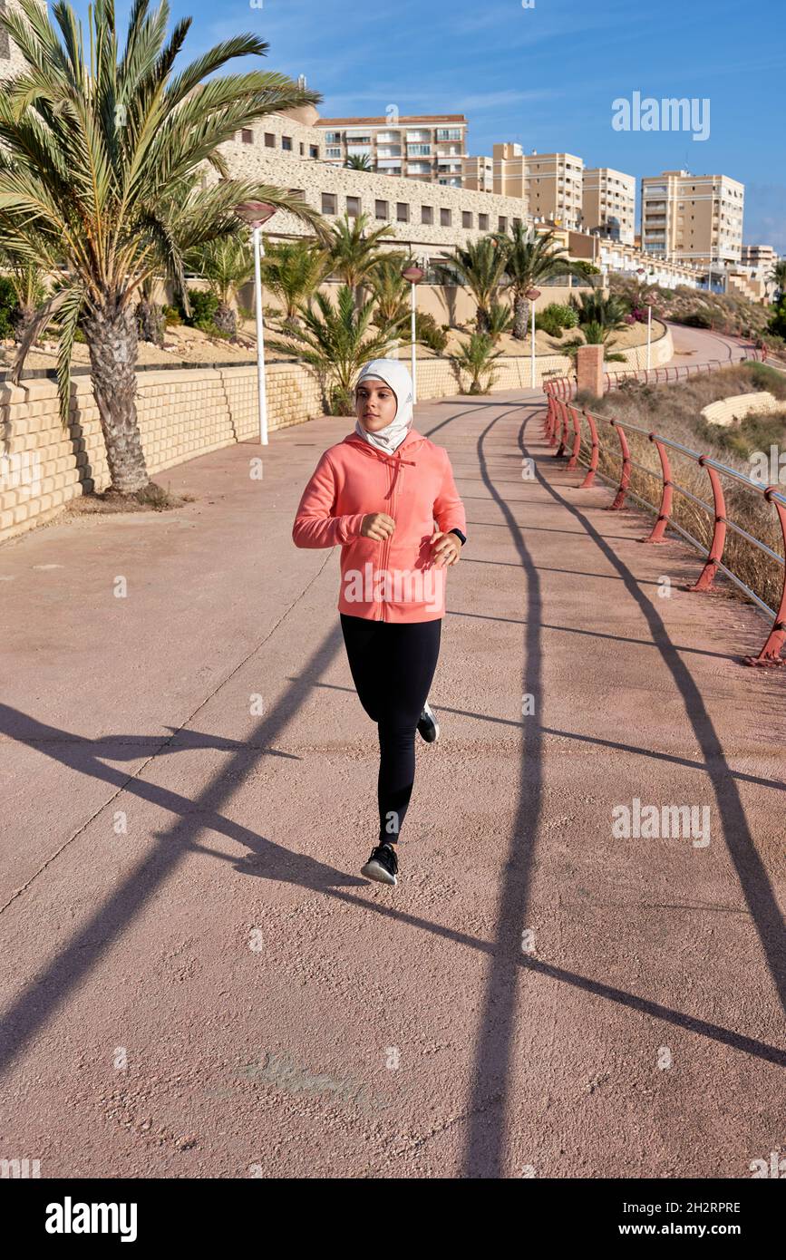 Gesunde sportliche Frau trägt Hijab joggen im Freien Stockfoto