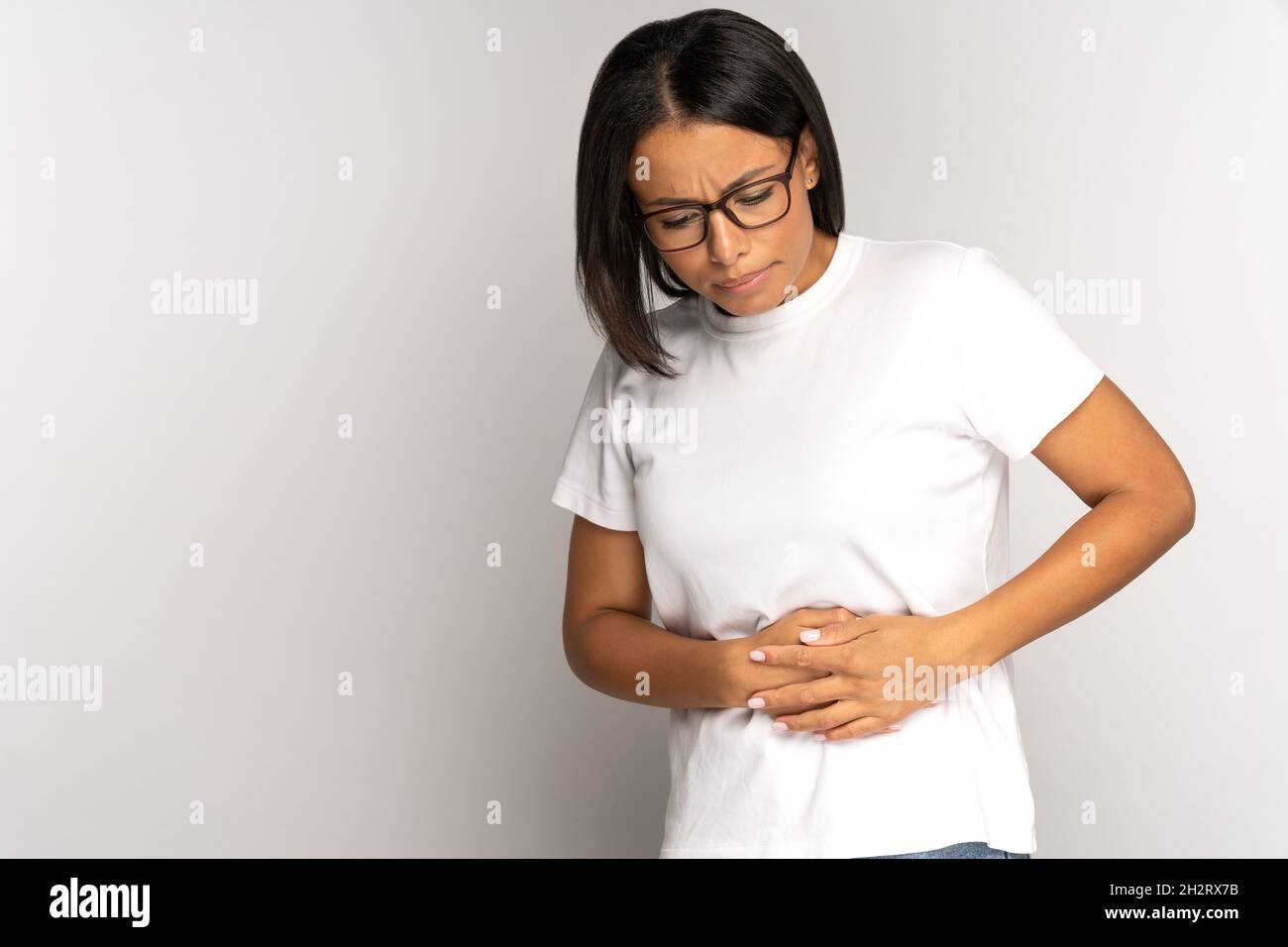 Traurige afroamerikanische Frau in der frühen Schwangerschaft, leiden unter Magenschmerzen Schmerzen berühren Bauch mit Armen Stockfoto
