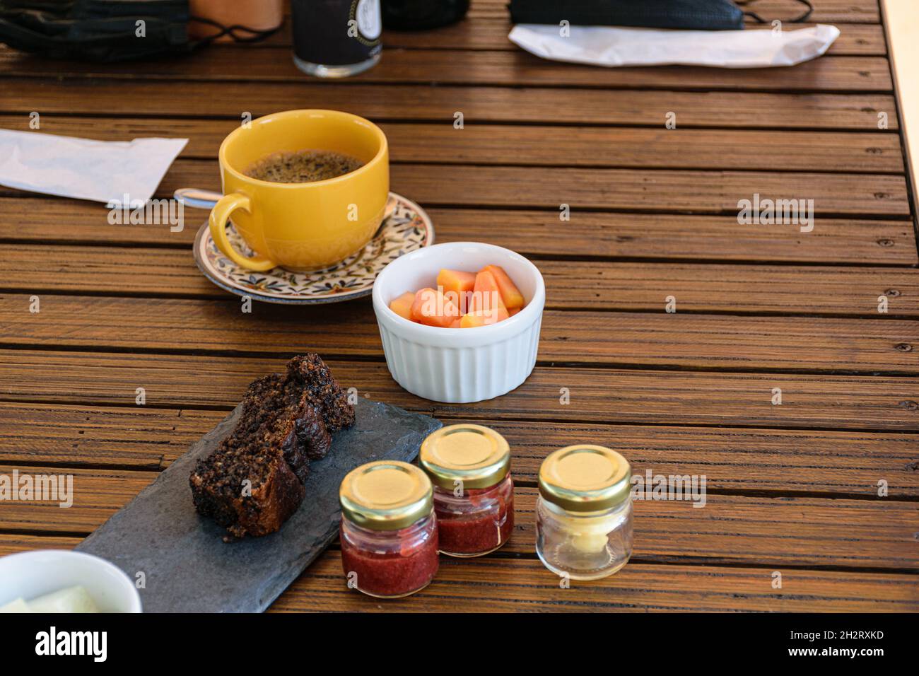 Kekskuchen neben einer Portion Papaya und verschiedenen Gelees. Stockfoto