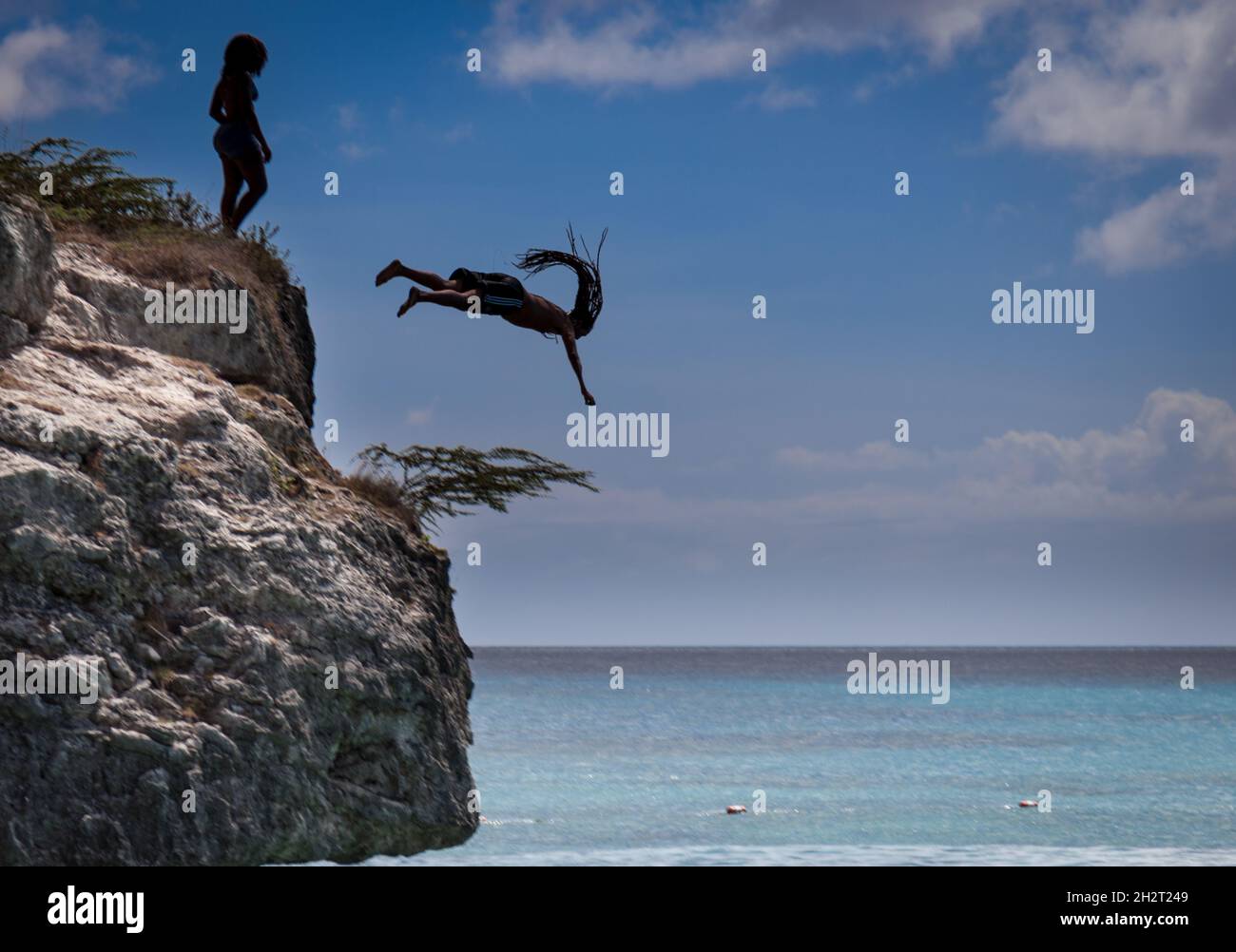 Junger Mann, der von der Klippe abtaucht. Stockfoto