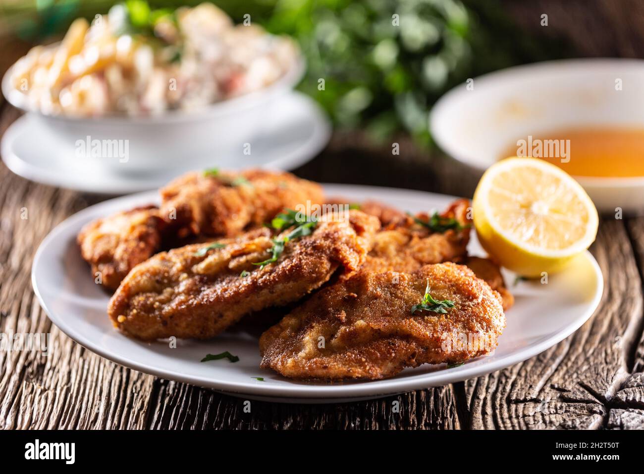 Gebratene Steaks und Kartoffelsalat, ein traditionelles Gericht, das zu Weihnachten oder Ostern serviert wird. Stockfoto