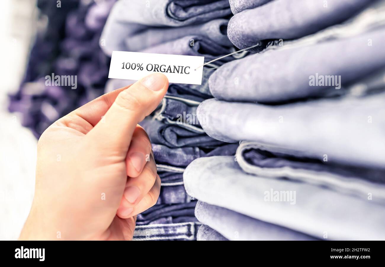 Bio-Jeans, ethisch einwandfreie Denim-Hose. Stapel von Kleidung im Regal. Etikett und Etikett. Nachhaltige Einzelhandelsmode und Qualitätsprodukt. Stockfoto